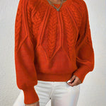 Orange cable-knit long-sleeve pullover with half-zip neckline and ribbed cuffs