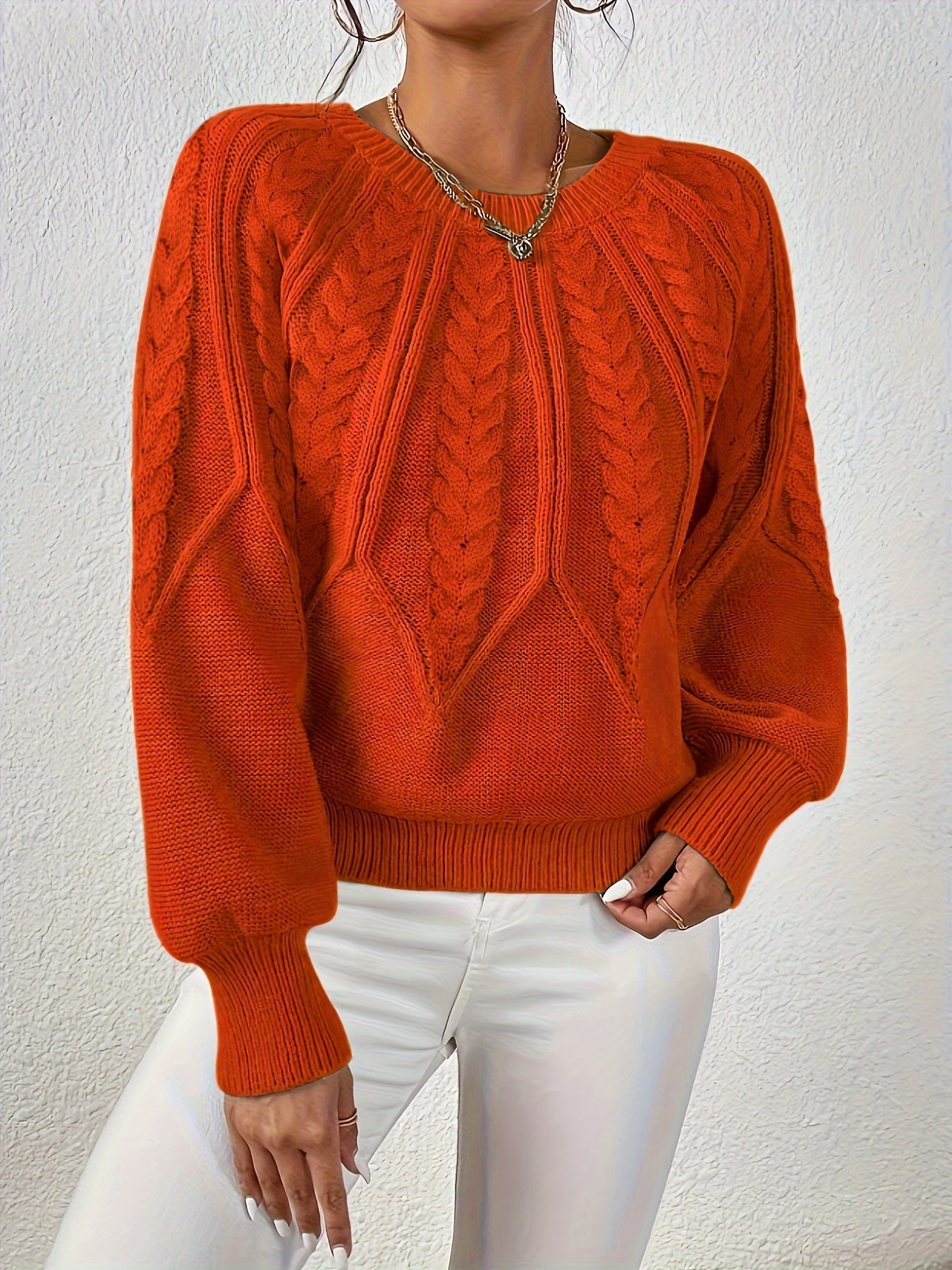 Orange cable-knit long-sleeve pullover with half-zip neckline and ribbed cuffs
