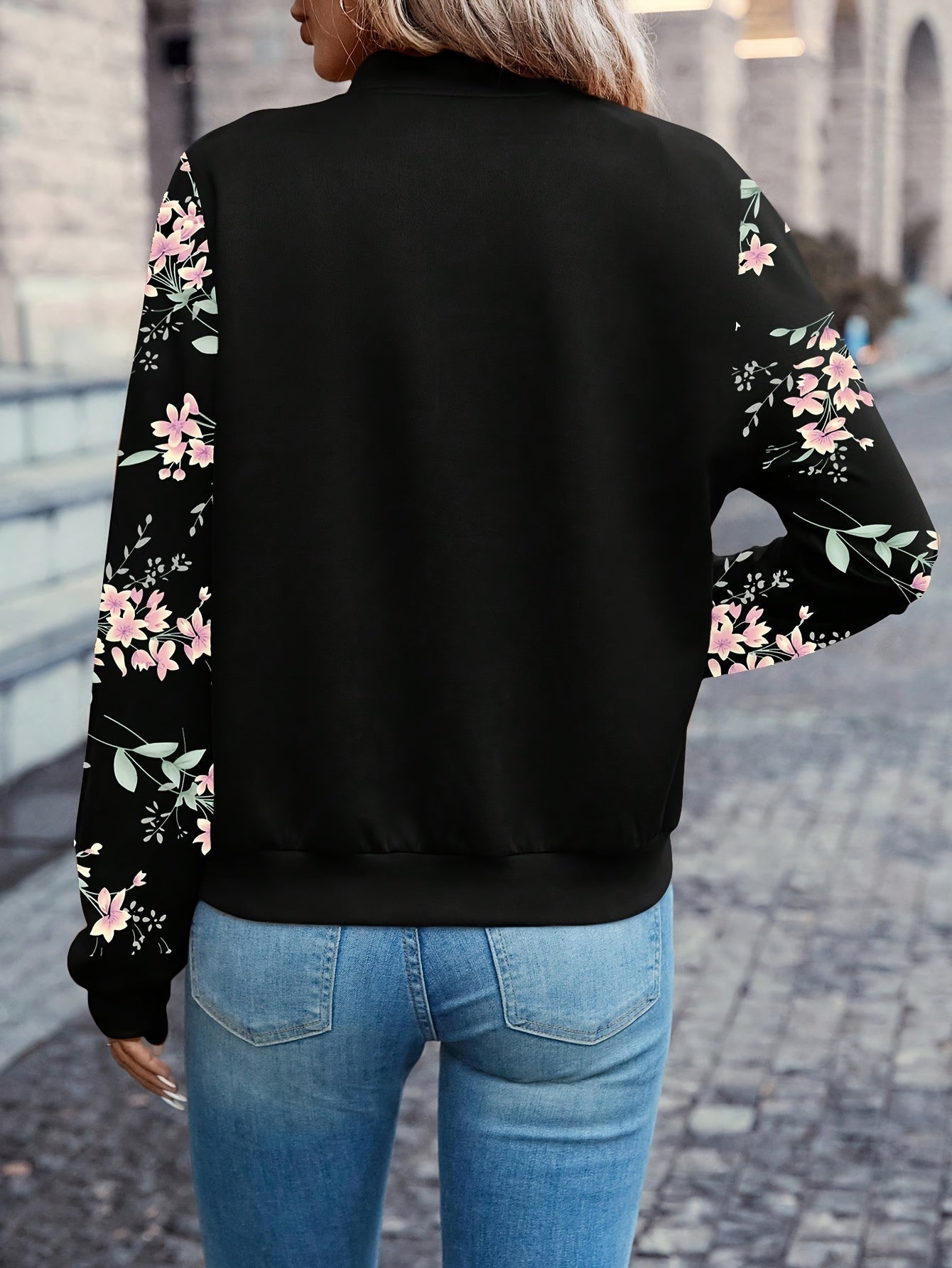 Black zip-up jacket with floral print sleeves, back view