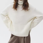 Ivory knit turtleneck sweater with long sleeves and ribbed cuffs