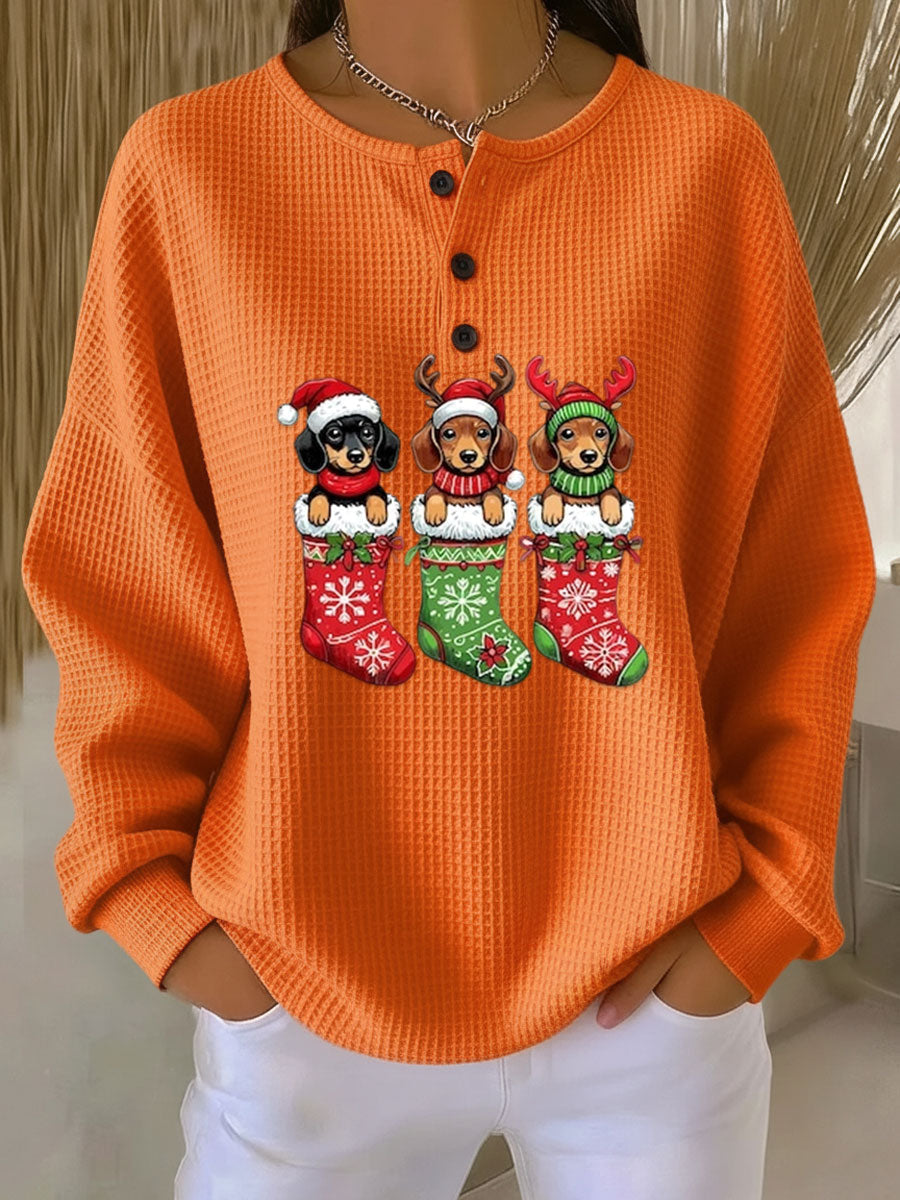 Orange vintage Christmas henley sweater with dog motif and festive stockings graphic