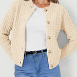 Cream textured knit cardigan with wood-style buttons and long sleeves, front view