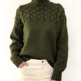 Women's cable-knit turtleneck sweater, dark green with raised front cable detail.