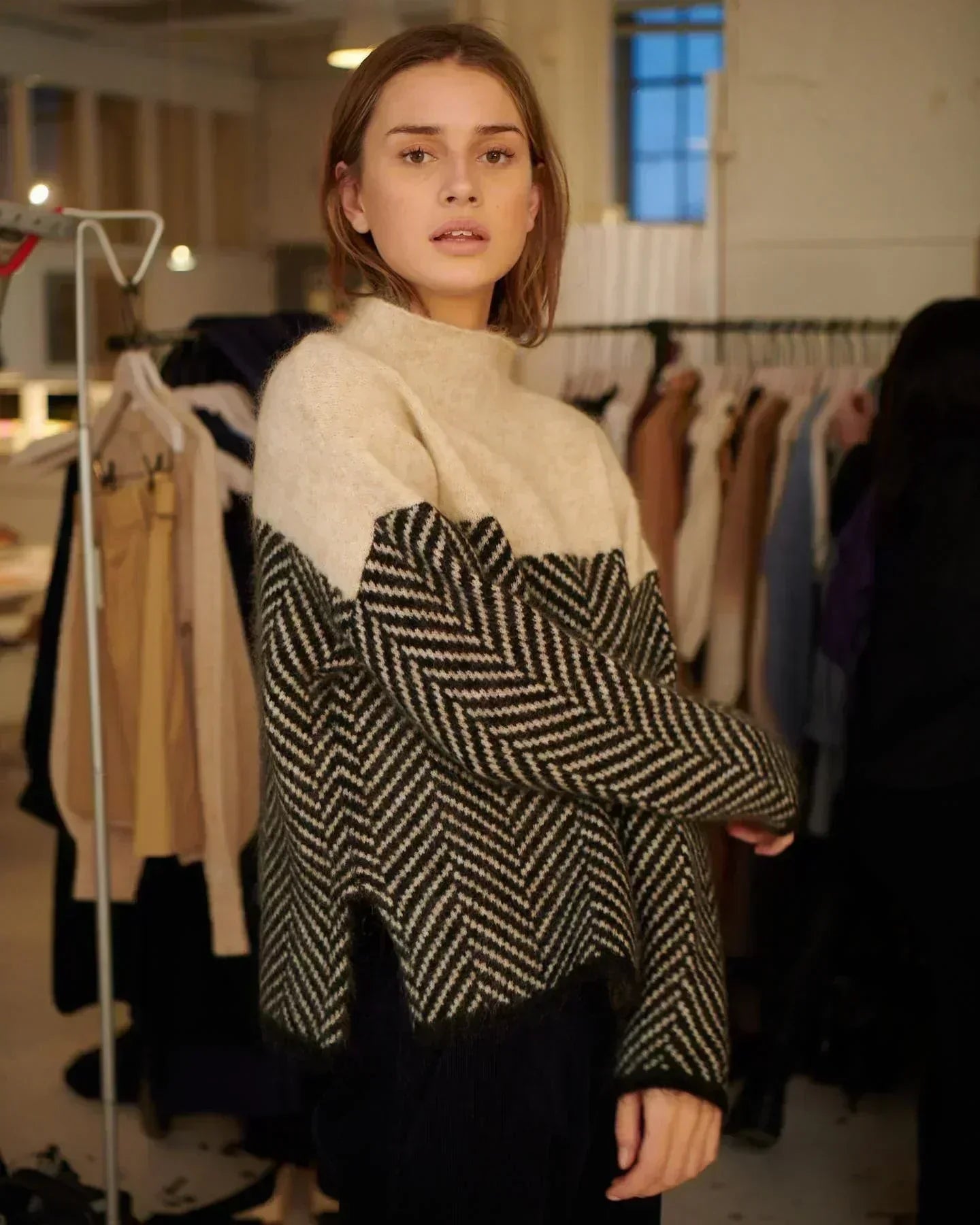 Beige turtleneck sweater with black-and-cream chevron panel and long sleeves