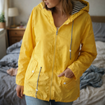 Yellow hooded rain jacket close-up: zip front and buttoned pockets