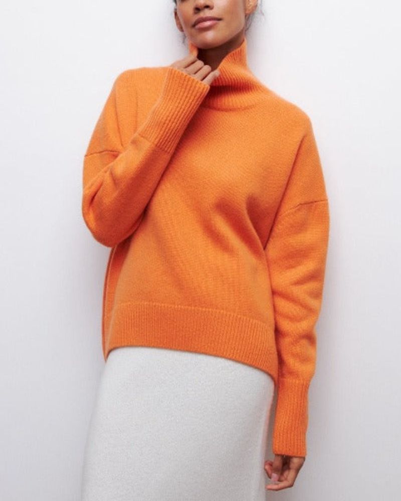Orange turtleneck sweater with long sleeves and ribbed knit trim