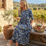 Navy midi dress with gold botanical print and three-quarter sleeves, gathered waist