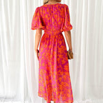 Pink-orange floral midi dress with puff sleeves and back tie detail, back view