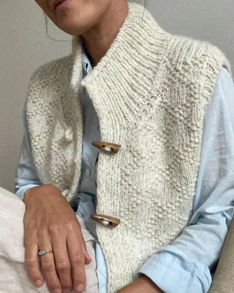 Cream textured sleeveless cardigan with five-button front and ribbed shawl collar