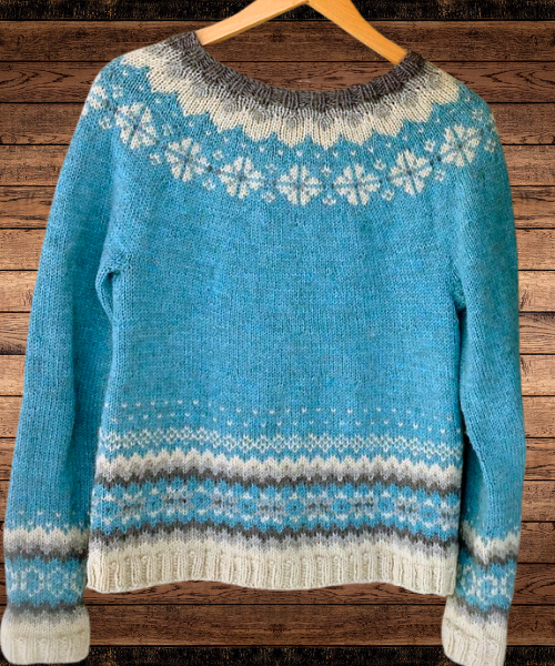 Blue knit pullover with geometric stripe hem and snowflake yoke, long sleeves