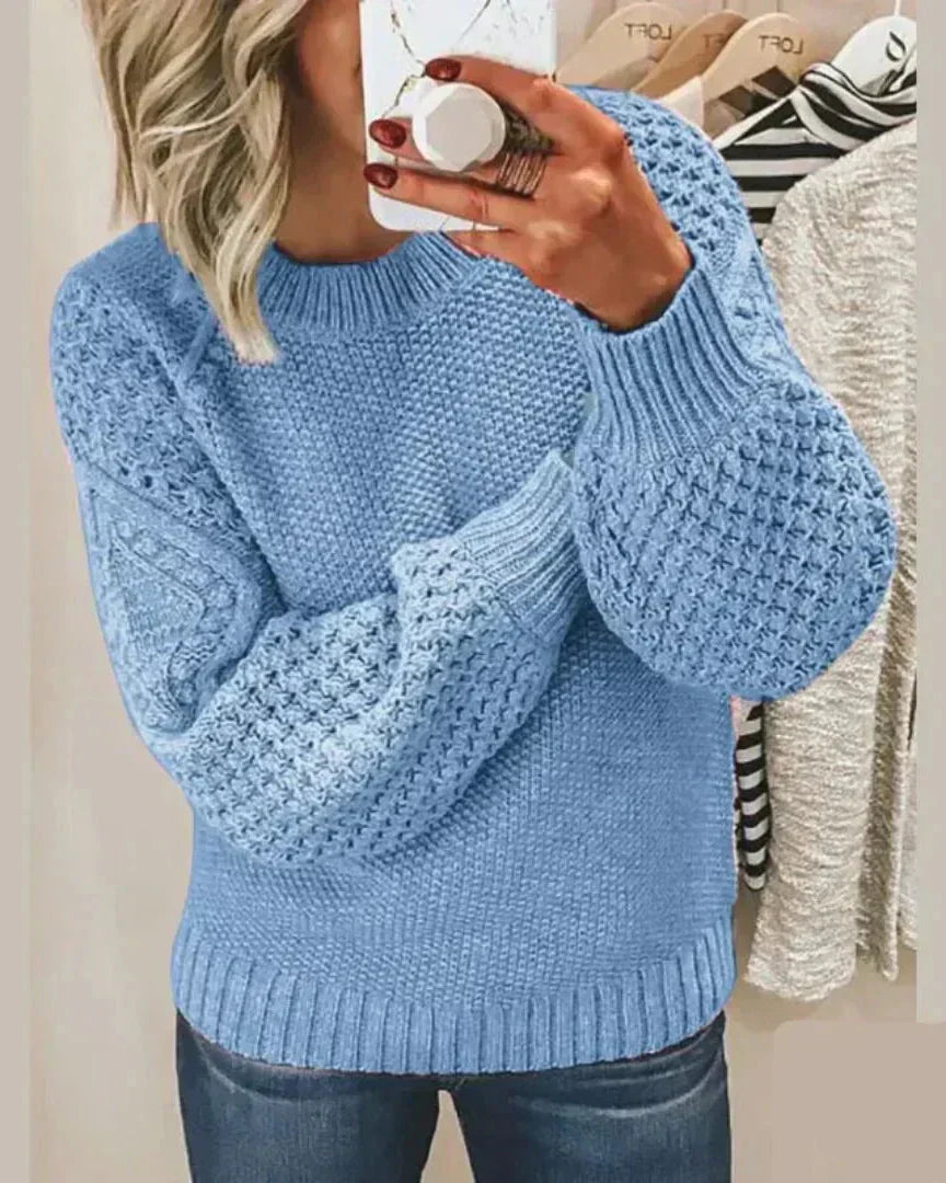 Light blue chunky knit pullover with long sleeves and crew neck, textured stitch detail