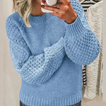 Light blue chunky knit pullover with long sleeves and crew neck, textured stitch detail