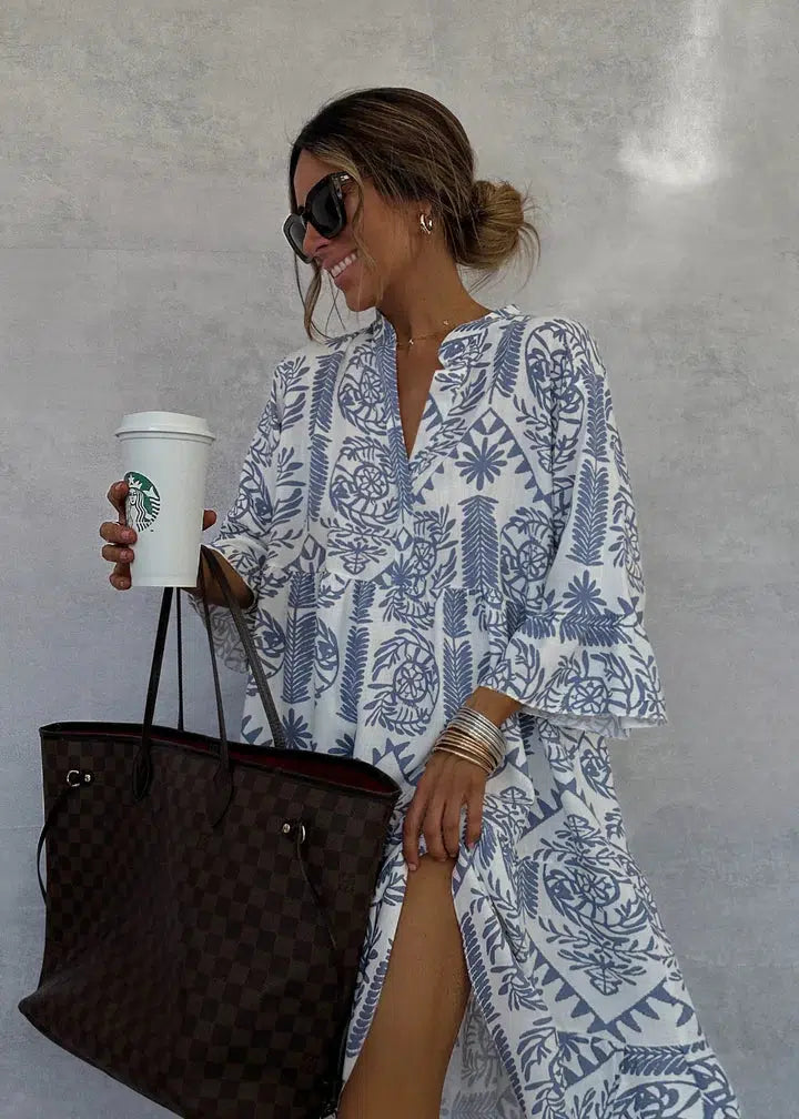 Blue-and-white patterned V-neck mini dress with long sleeves and tiered, flared look.