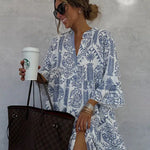 Blue-and-white patterned V-neck mini dress with long sleeves and tiered, flared look.