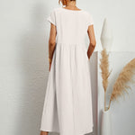 White midi casual dress from back view with short sleeves and gathered waist, flared skirt