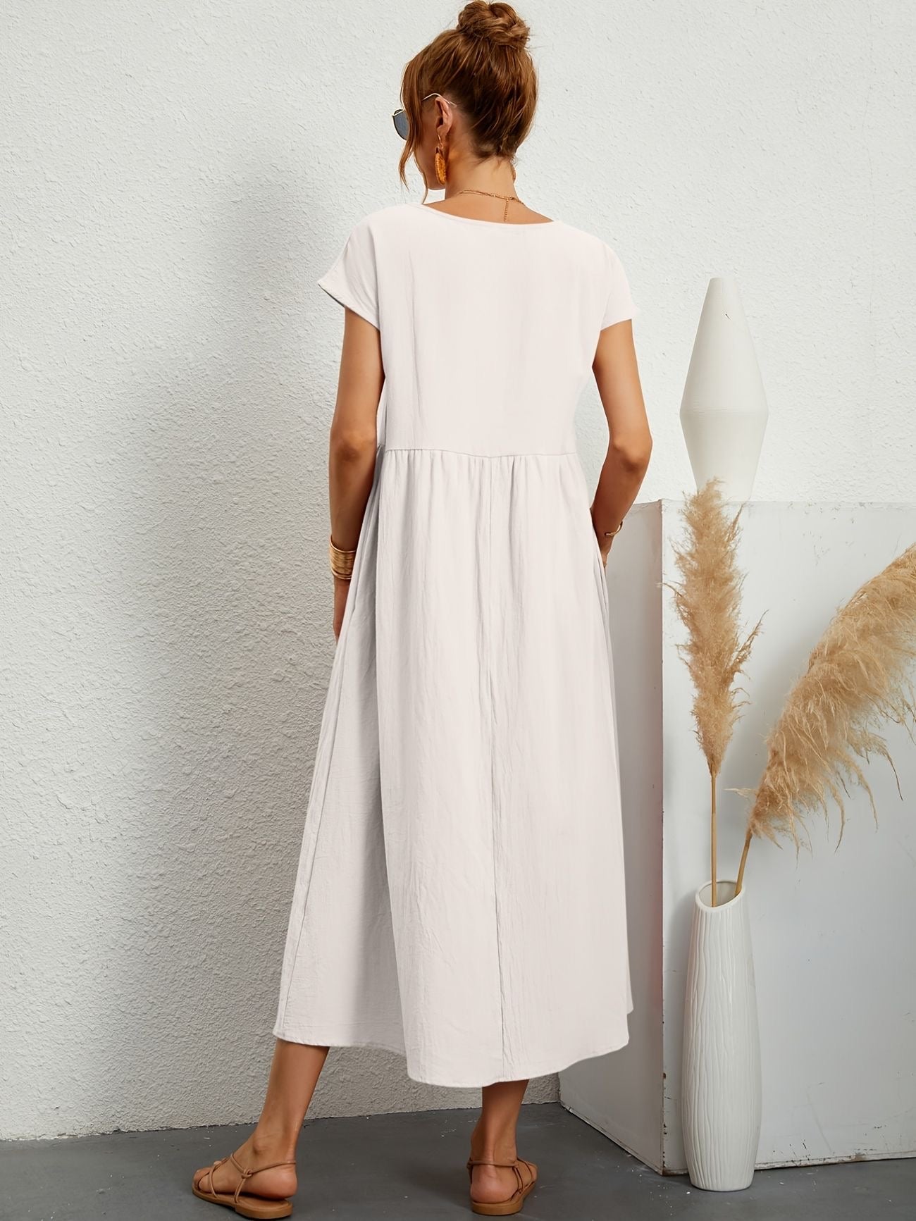 White midi casual dress from back view with short sleeves and gathered waist, flared skirt