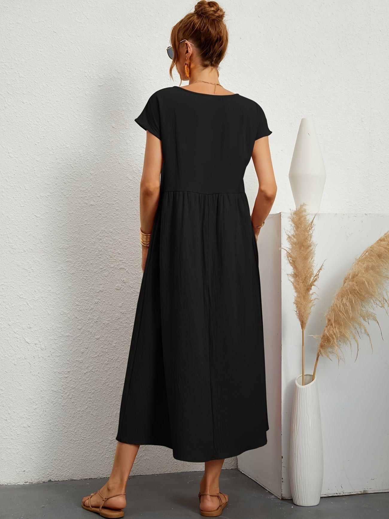 Black midi casual dress from back view with short sleeves and gathered waist, flared skirt