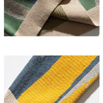 Beige crew pullover side closeup with striped knit panel and ribbed cuff
