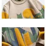 Beige knit crew pullover closeup with cat graphic and ribbed cuffs