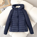 Women’s light hybrid quilted jacket with hood, navy, zip-up front on chair
