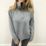 Grey long-sleeve knit pullover with button placket and stand collar, ribbed cuffs