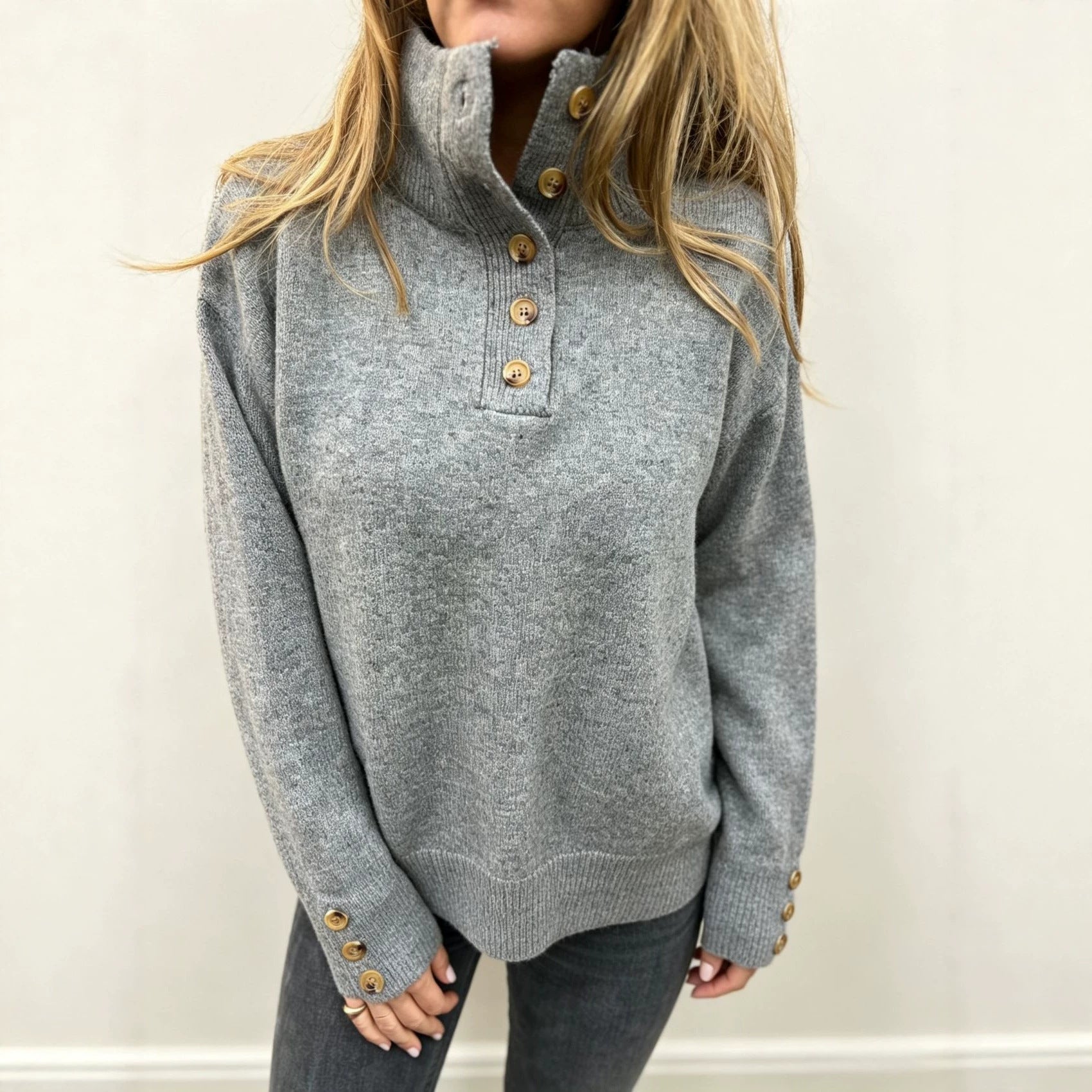 Grey long-sleeve knit pullover with button placket and stand collar, ribbed cuffs