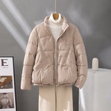 Women's short quilted jacket in light beige, high collar, zip front, flap pockets.