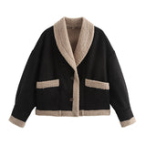 Black short button jacket with beige sherpa lining, chest pockets, and cuff trim