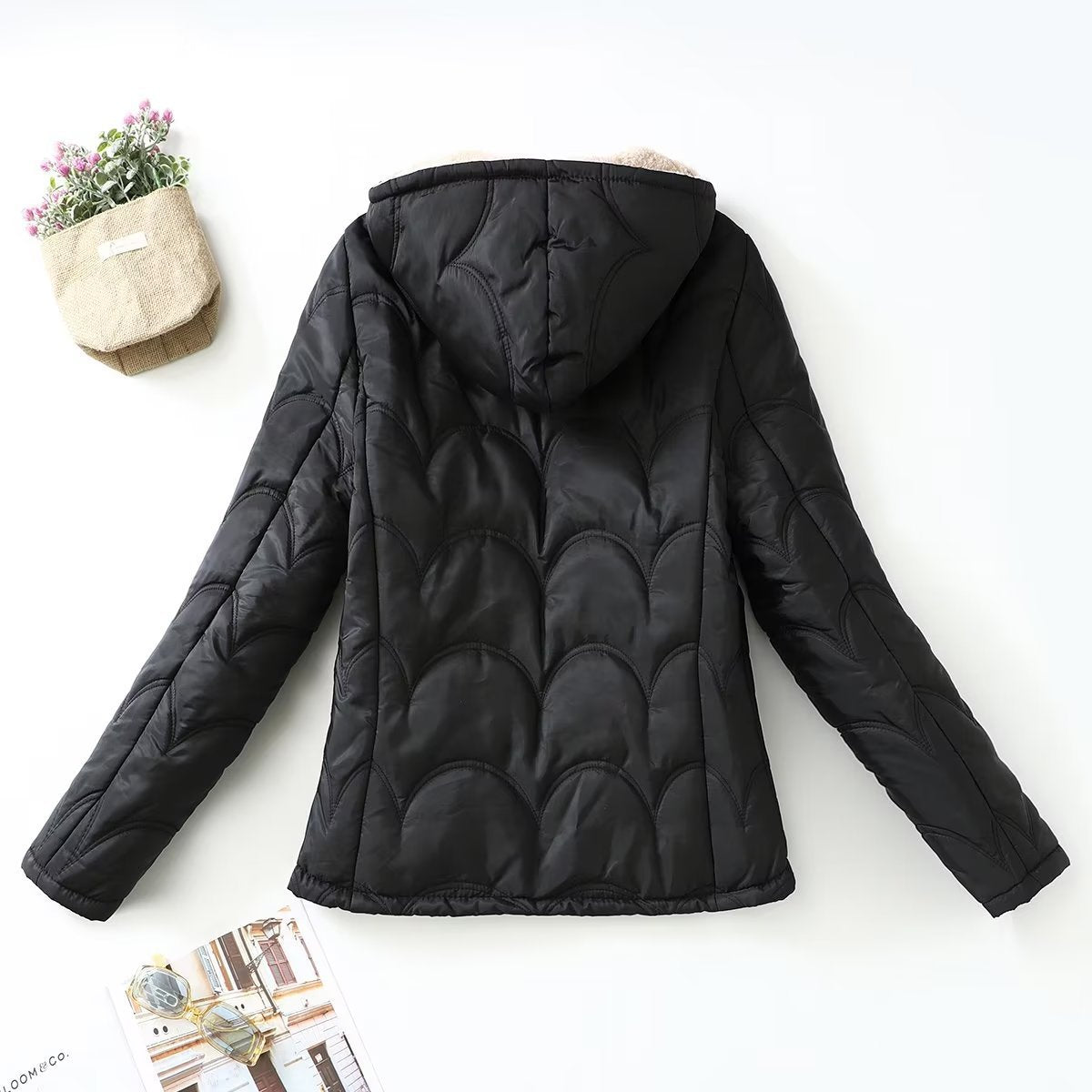 Women's black quilted hooded jacket with beige sherpa lining, back view