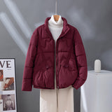 Women's short quilted jacket in burgundy, high collar, zip front, flap pockets.