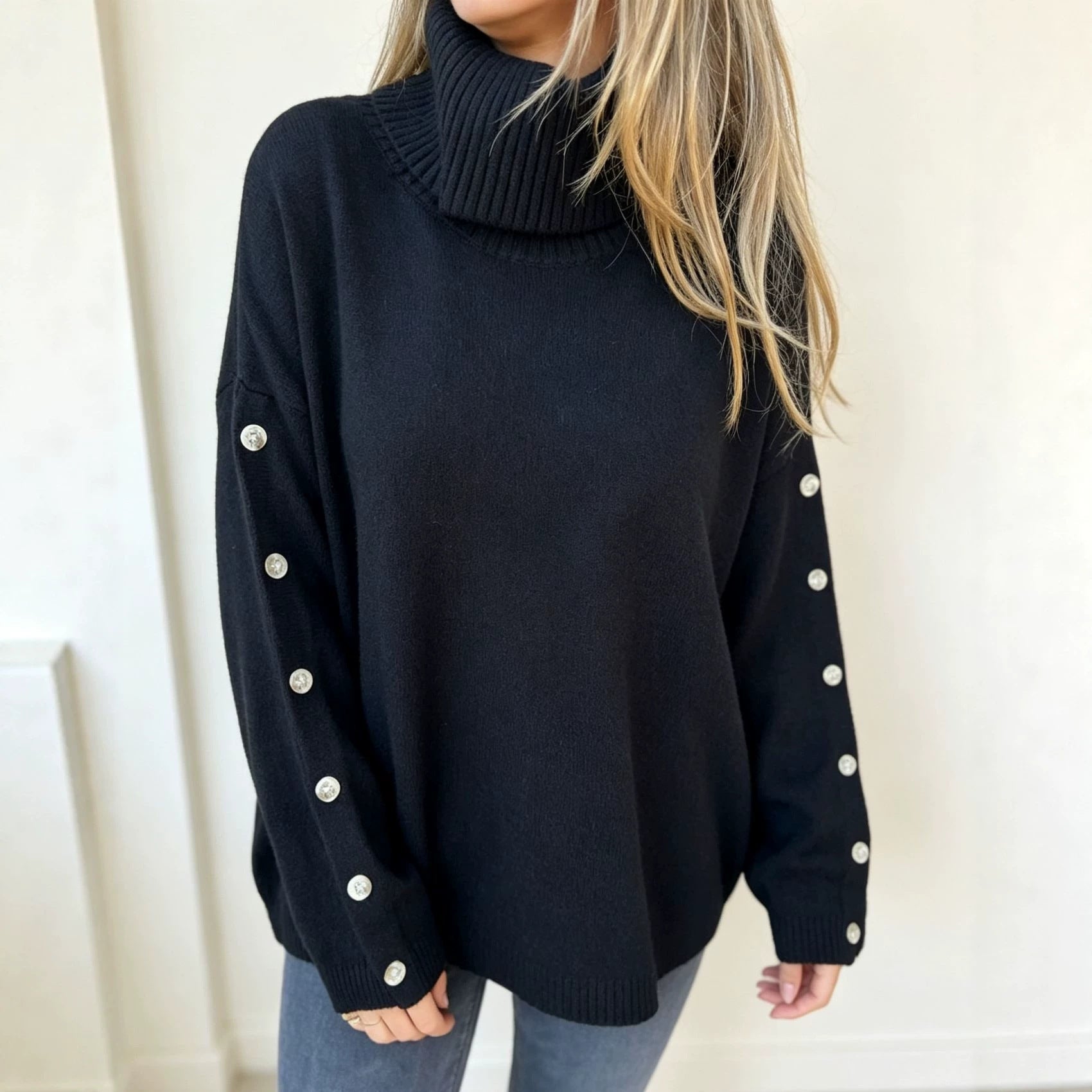 Oversized dark navy knit turtleneck pullover with buttoned cuffs, long sleeves