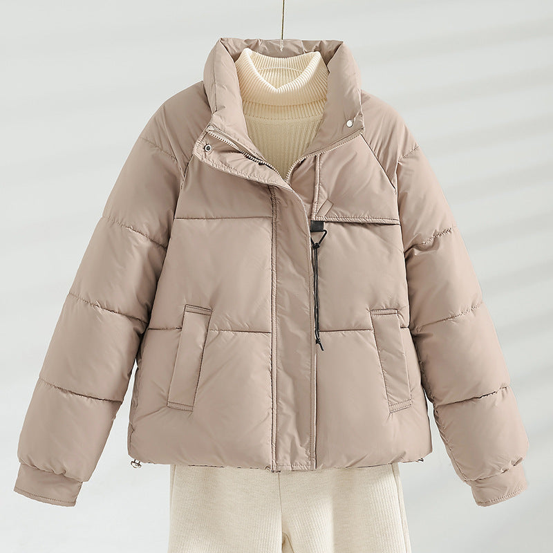 Beige short quilted jacket with stand collar, front zipper, and side flap pockets