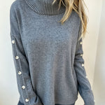 Oversized blue-gray long-sleeve turtleneck sweater with buttoned sleeve cuffs