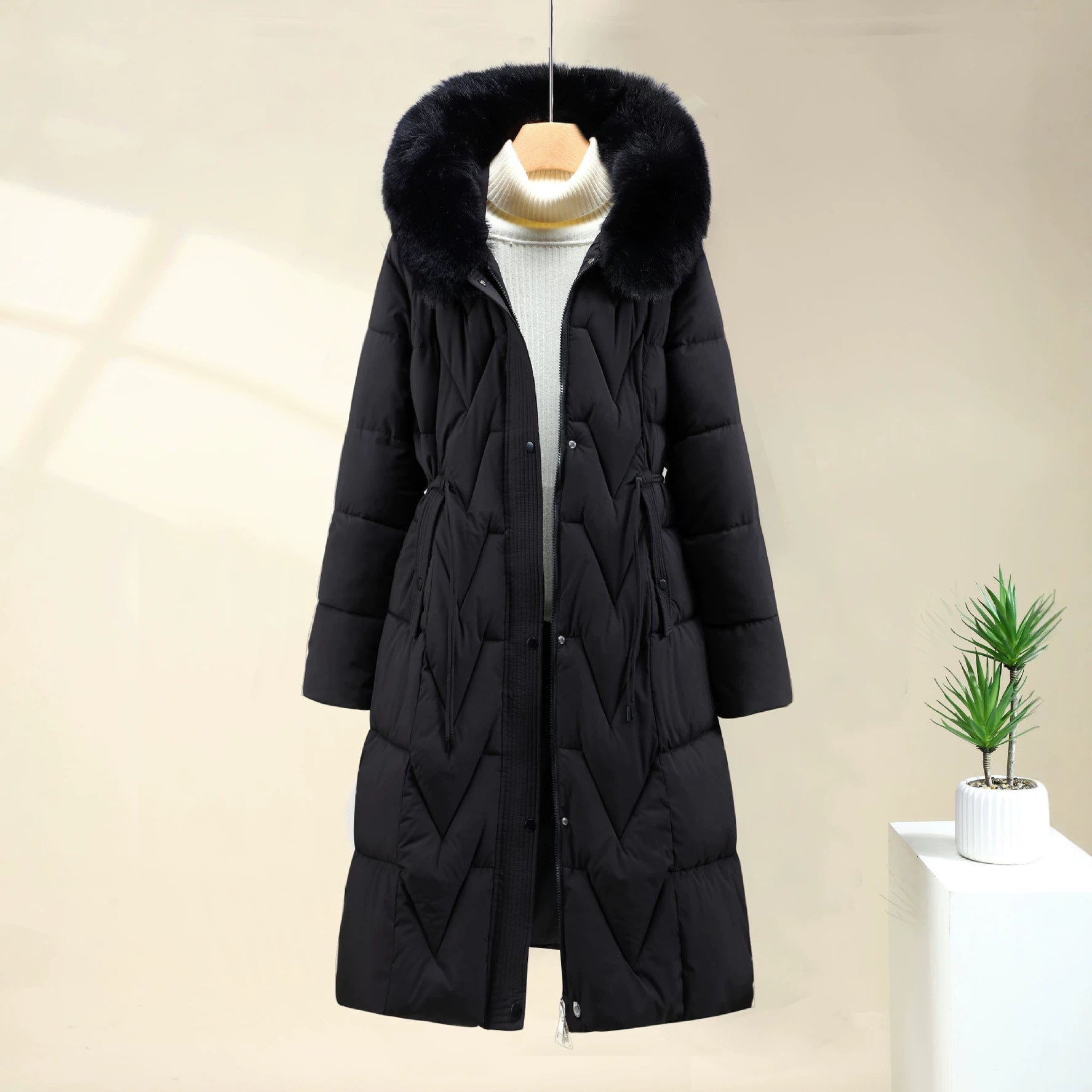 Long black quilted parka with removable faux-fur hood, drawstring waist, button front