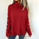 Oversized red knit turtleneck pullover with buttoned cuffs and long sleeves