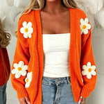 Orange oversized long-sleeve cardigan with white flower appliqués and open front
