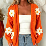 Orange oversized long-sleeve cardigan with white flower appliqués and open front