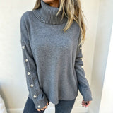 Oversized blue-gray knit turtleneck pullover with buttoned cuffs, long sleeves
