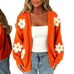 Oversized orange long-sleeve cardigan with white daisy flower appliqués.