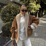 Tan short button jacket with sherpa trim, chest pockets, and long sleeves