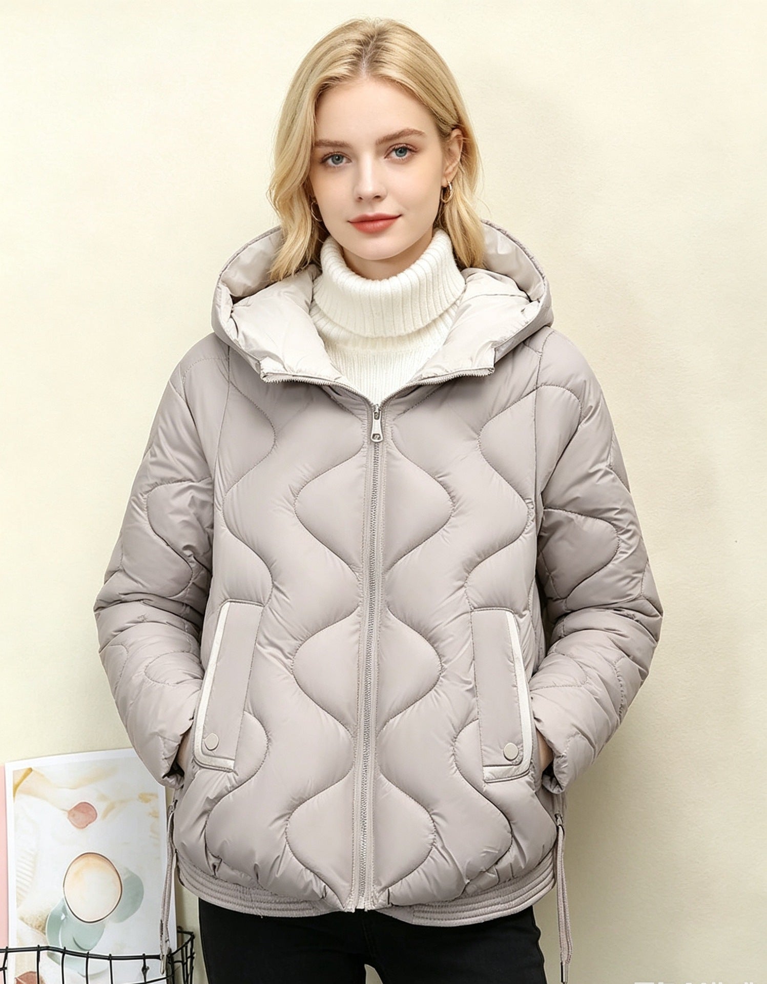 Light gray quilted short jacket with hood, heart stitching, front zipper and side pocket openings.