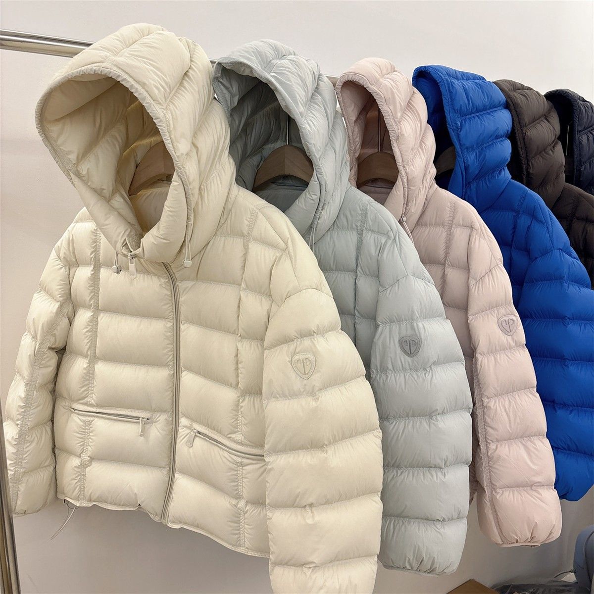 Short padded hooded thermal jacket in off-white with full-zip front and side zip pockets