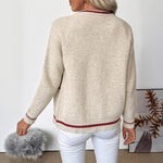 Back view of beige knit zip-up bomber cardigan with red-striped hem and ribbed cuffs