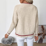 Back view of beige knit zip-up bomber cardigan with red-striped hem and ribbed cuffs