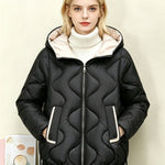 Black quilted short jacket with hood, heart stitching, central zip front and side pocket openings.