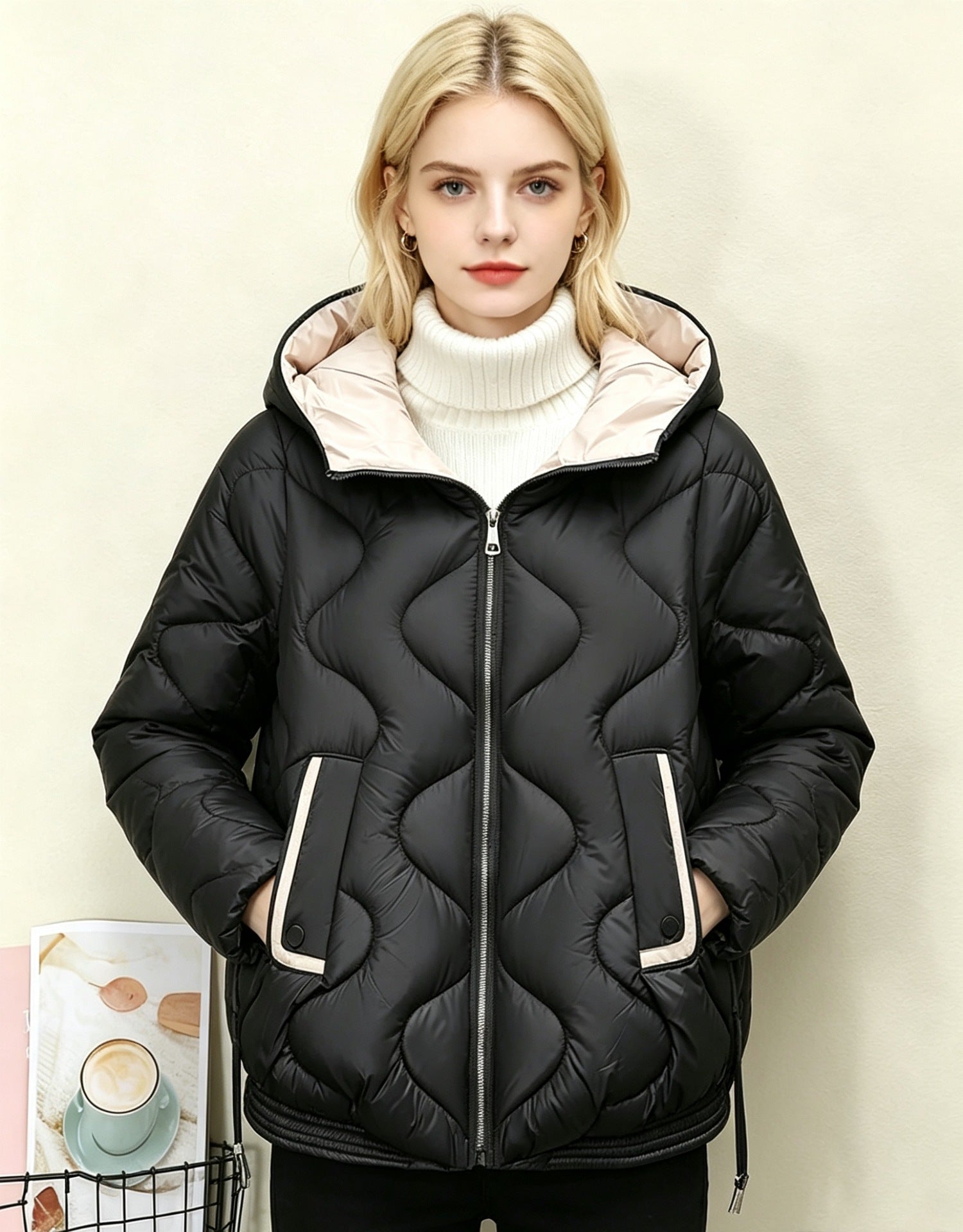 Black quilted short jacket with hood, heart stitching, central zip front and side pocket openings.