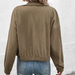 Cropped long-sleeve jacket back view in olive textured fabric with full button placket.