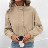 Cropped long-sleeve olive jacket with textured weave, snap buttons, and visible side pockets.