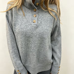 Grey knit long-sleeve pullover with buttoned neckline and ribbed hem, gold-tone buttons