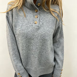 Grey knit long-sleeve pullover with buttoned neckline and ribbed hem, gold-tone buttons
